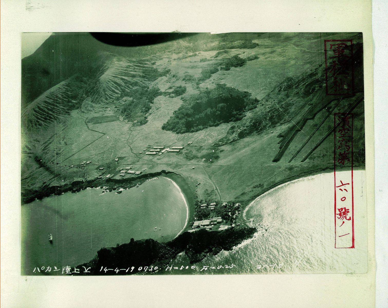 An green-toned aerial image of a World War II era Japanese airfield, labelled in Japanese, on the island of Pågan in the Northern Mariana Islands.