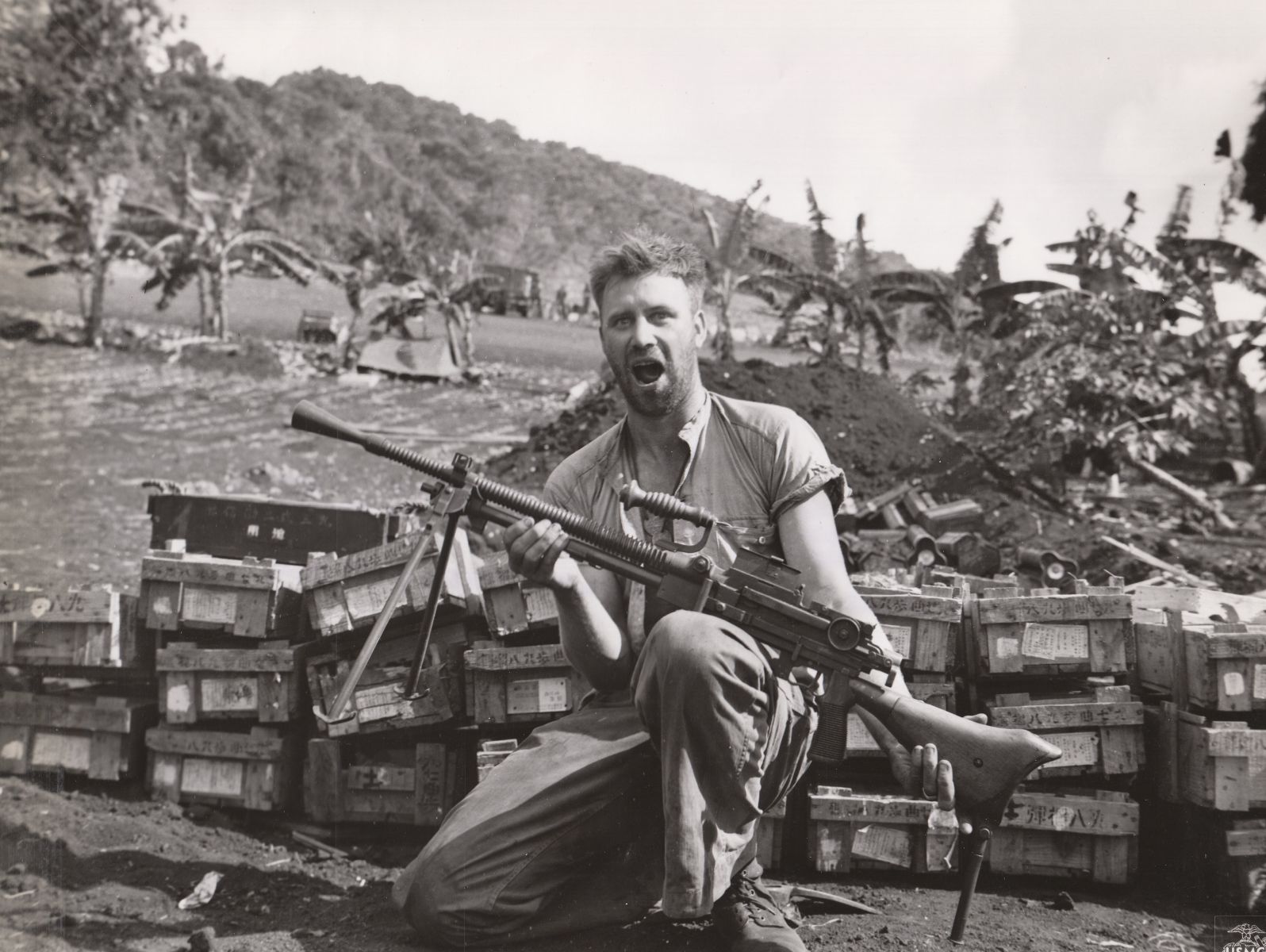 A young soldier holds up a large military rifle while kneeling, with his jaw dropped in excitement.